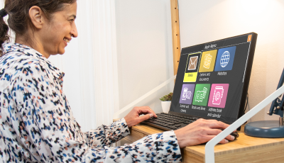 Cheerful lady using GuideConnect on a desktop computer.
